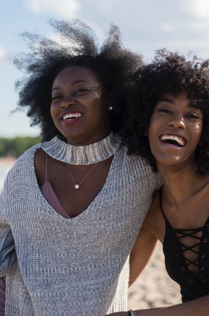 photo of woman beside another woman at seashore
